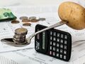Money Scales from a calculator and a spoon with coins and potatoes.jpg